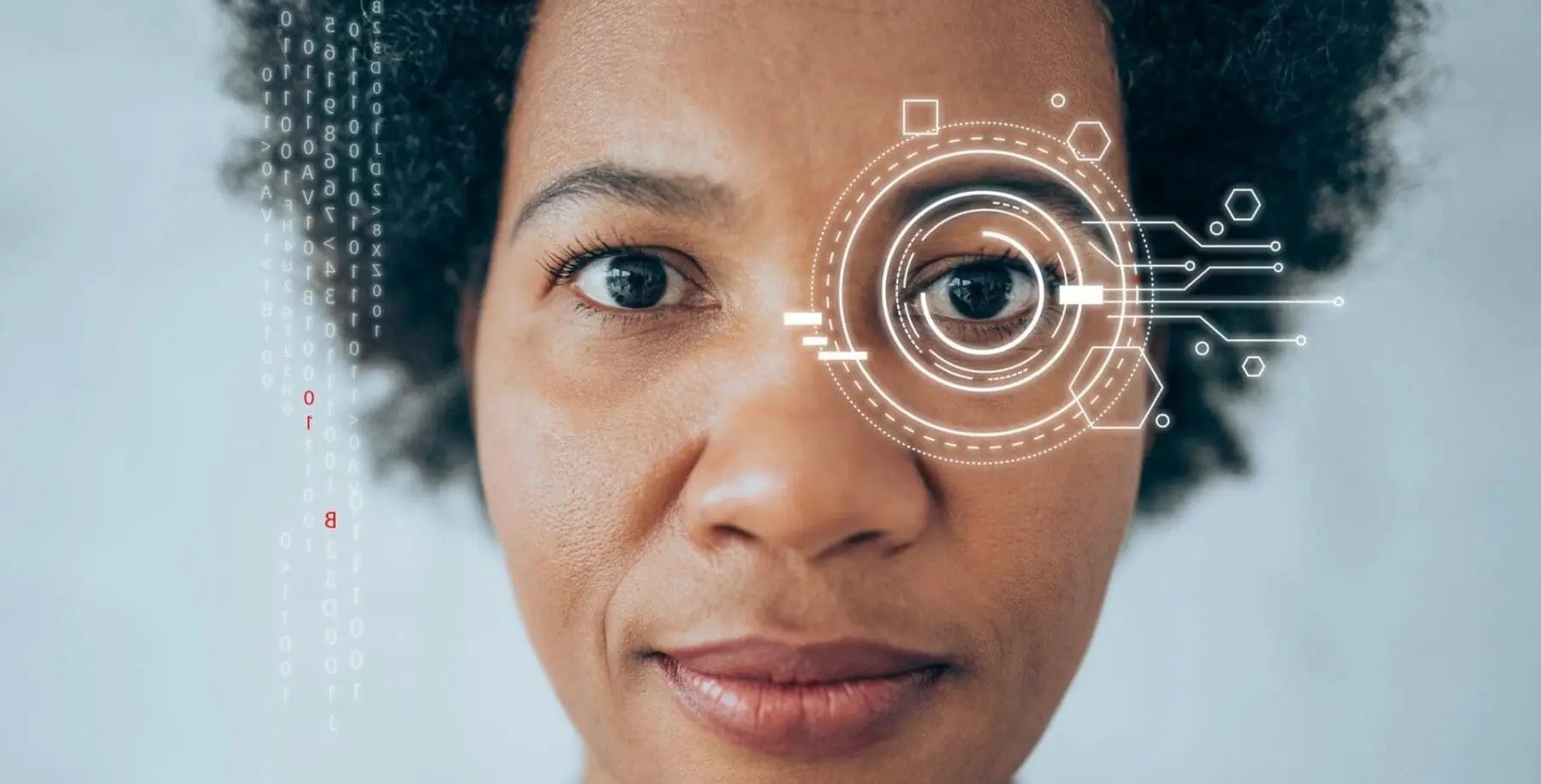 Adherent (formerly Compliance & Risks). Close-up of a woman's face with a digital interface overlay on her right eye and alphanumeric code on the left side of the image.