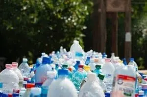Adherent (formerly Compliance & Risks). A large collection of plastic bottles with various colored caps, densely packed together outdoors.