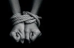 Adherent (formerly Compliance & Risks). Two hands tied together with rope, clenched into fists, in black and white.