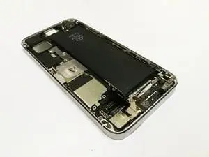 Disassembled smartphone showing its internal black battery and silver circuit board components.