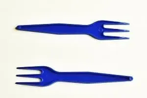 Two blue plastic forks on a white background.