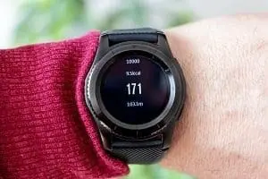 Adherent (formerly Compliance & Risks). Close-up of a black smartwatch on a wrist, displaying '171' prominently, along with '10000', '1500kcal', and '10.0km' on its screen.
