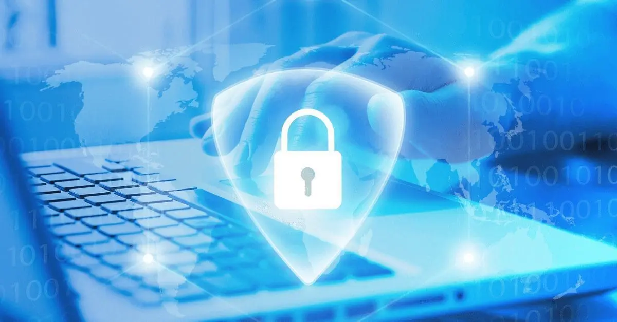 Adherent (formerly Compliance & Risks). A glowing white shield with a padlock icon overlaid on a blue image of hands typing on a laptop, a world map, and binary code.