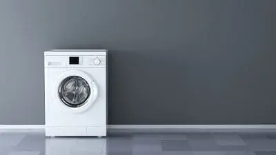 Adherent (formerly Compliance & Risks). A white front-loading washing machine against a dark gray wall with a tiled floor.