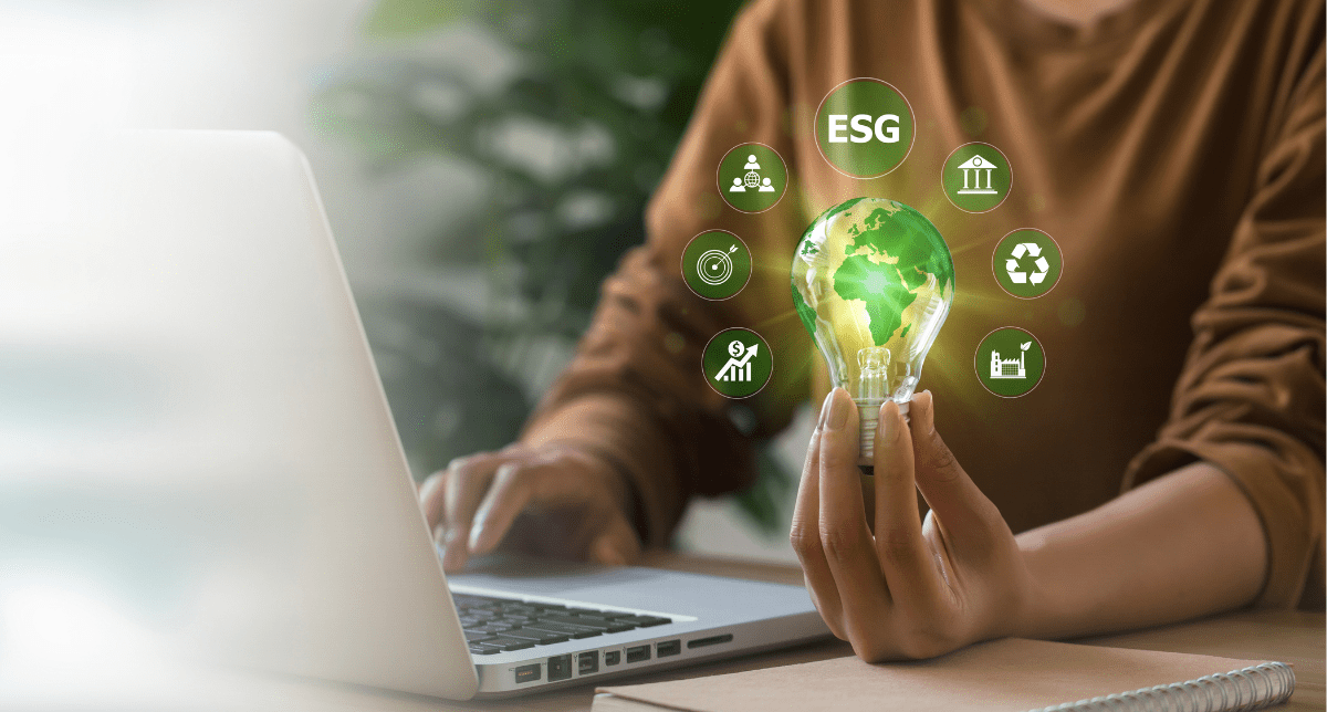 Adherent (formerly Compliance & Risks). Woman's hand holding a lightbulb surrounded by ESG icons - concept for ESG 2024 A Year in Review