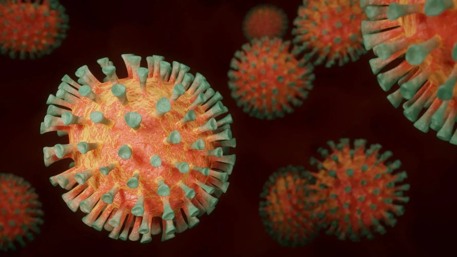 Adherent (formerly Compliance & Risks). A 3D rendering of multiple virus particles, with one large, orange and yellow particle covered in green spikes in the foreground, and others blurred in the background.