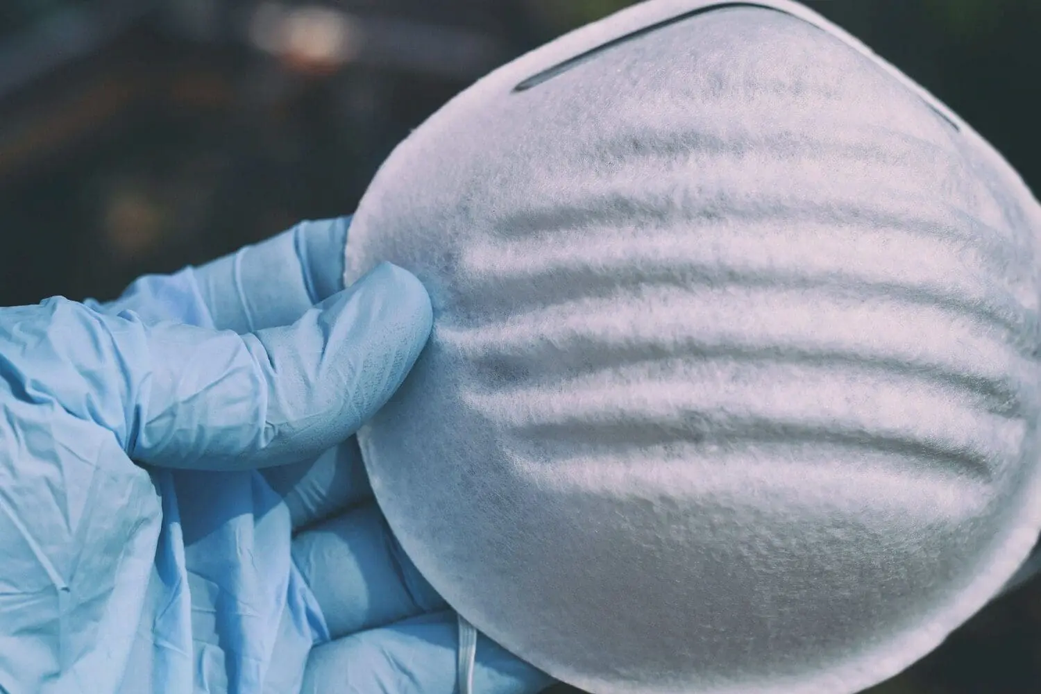 Adherent (formerly Compliance & Risks). A hand in a light blue disposable glove holds a white respiratory mask.
