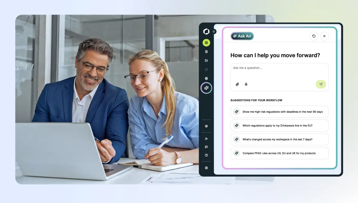 Two smiling professionals, a man and a woman, look at a laptop screen. An overlay shows an AI assistant interface named 'Ask Ari' with workflow suggestions related to regulations and product comparisons.