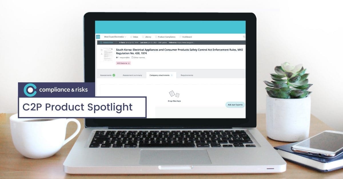 A silver laptop on a wooden desk displays a compliance software interface detailing a South Korean regulation. A white coffee mug, a succulent plant, a notebook, and a smartphone are also on the desk. A 'C2P Product Spotlight' overlay is in the corner.