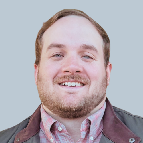 Headshot of a smiling man with a beard and blue eyes.