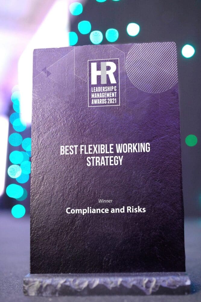 A dark award plaque for 'BEST FLEXIBLE WORKING STRATEGY' won by 'Compliance and Risks' at the HR Leadership & Management Awards 2021.