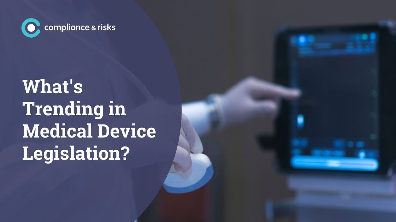 Text 'What's Trending in Medical Device Legislation?' over a blurred image of a gloved hand holding a medical device and another hand interacting with a digital screen.