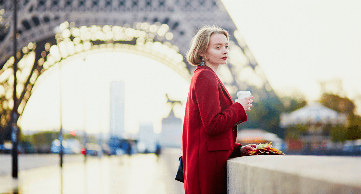 Woman wearing red coat at eiffel tower - concept for French Environmental Cost of Textiles
