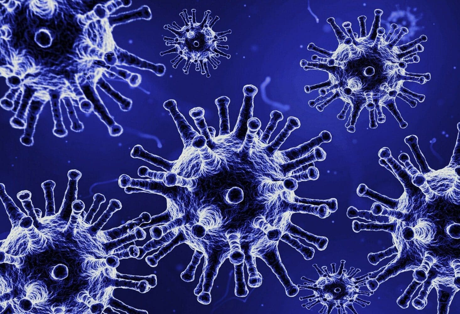 Illustration of multiple blue and white virus particles with spiky surfaces against a dark blue background.