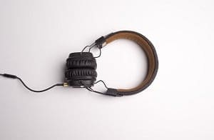 Black over-ear headphones with a brown headband, folded, on a white background.